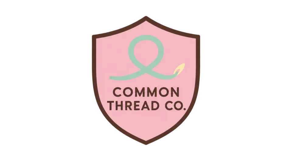 Common Thread Co. emblem logo idea: The simple thread loop ties the name to clothing, and the shield gives Common Thread Co. a tidy streetwear badge.