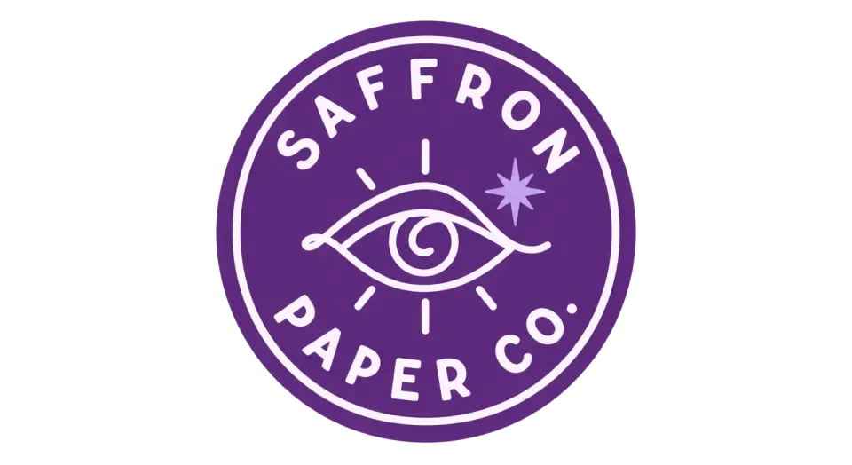 Saffron Paper Co. emblem logo idea: A clear, expressive eye sits at the heart of the badge, with the studio name circling it like a maker’s seal.